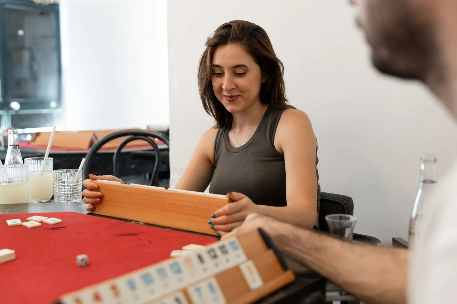 A woman engaging in a board game with friends in a casual indoor setting, creating a relaxed atmosphere.